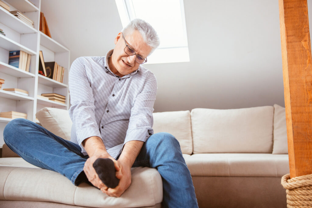 Senior man suffering with foot cramp