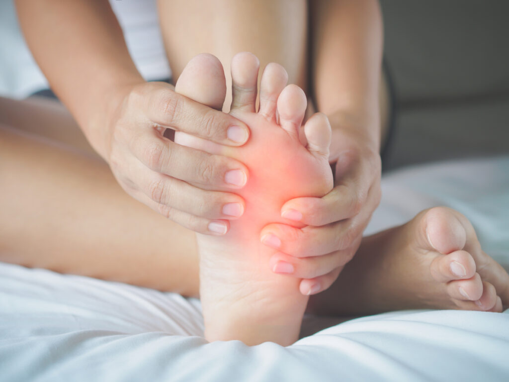 Woman feeling pain in her foot at home