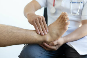 The doctor is diagnosing the foot pain of patient