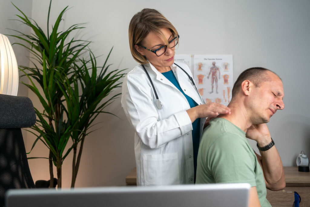 A female neck and spine specialist conducts a medical exam for neck pain on her patient.