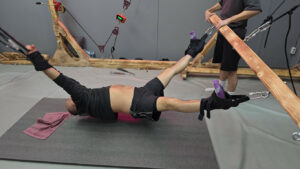 A male patient undergoes spinal and back decompression therapy on stretching straps.