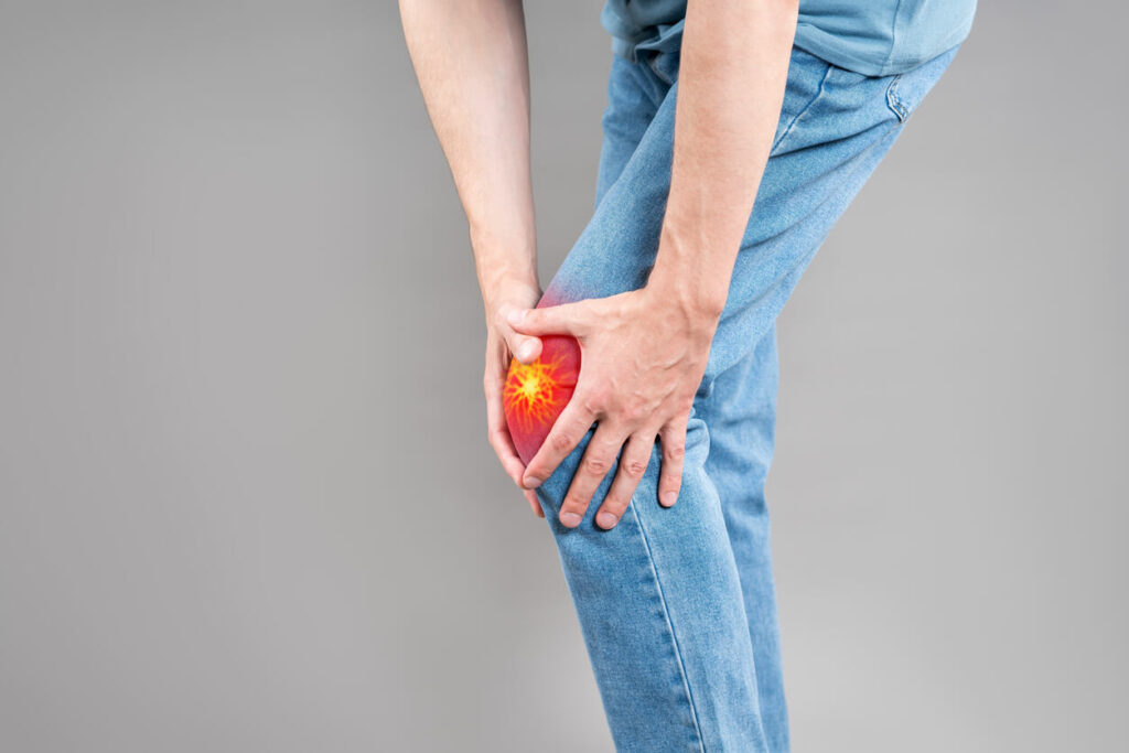 A man suffering from knee pain from osteoarthritis, causing him to hold his knees.