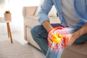 Man suffering from arthritic knee pain at home.